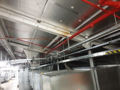 Black foam lagging wrapped around hot water pipes in a roof space